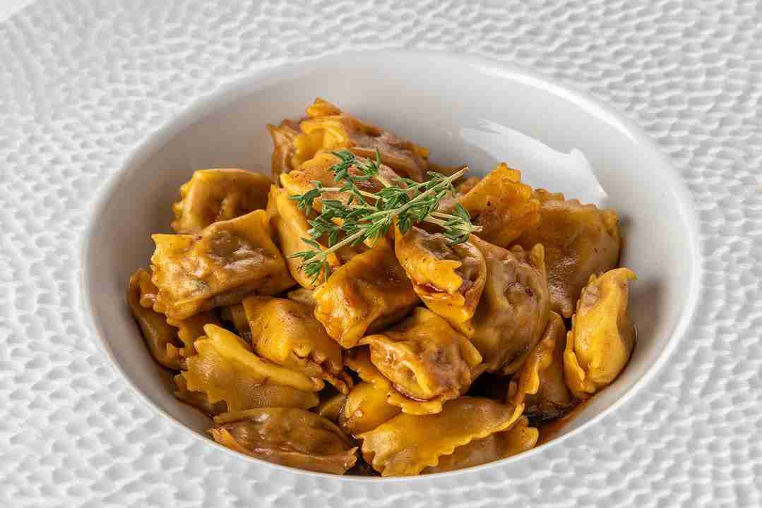 Ravioli del Plin, farci avec Bœuf, Épinards, Parmigiano, sauce de Lapin avec Pignons de Pin et Olives Noir